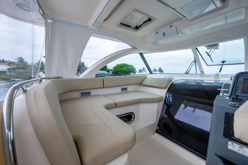 Bottoms Up II Yacht Photos Pics Luxurious interior of 2009 Pursuit OS 375 Offshore boat with beige seating and modern controls.