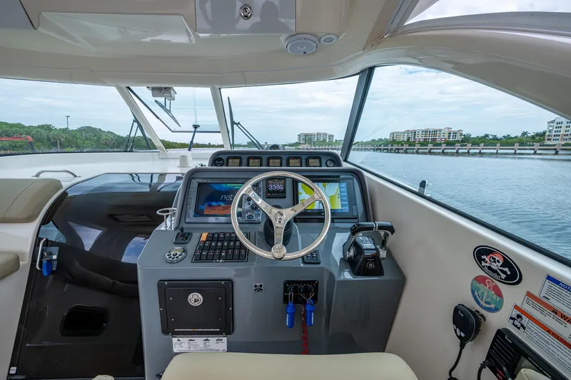 Bottoms Up II Yacht Photos Pics 2009 Pursuit OS 375 Offshore helm with navigation system and waterfront view.