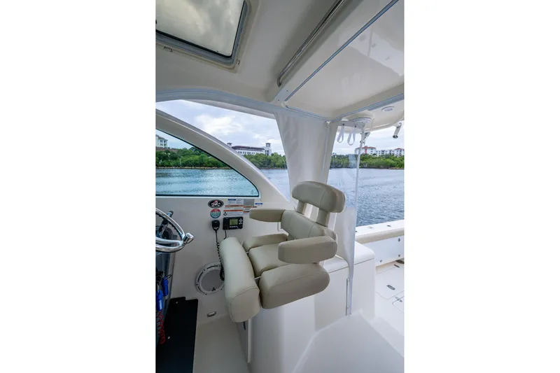 Bottoms Up II Yacht Photos Pics 2009 Pursuit OS 375 Offshore boat interior with helm seat and water view.