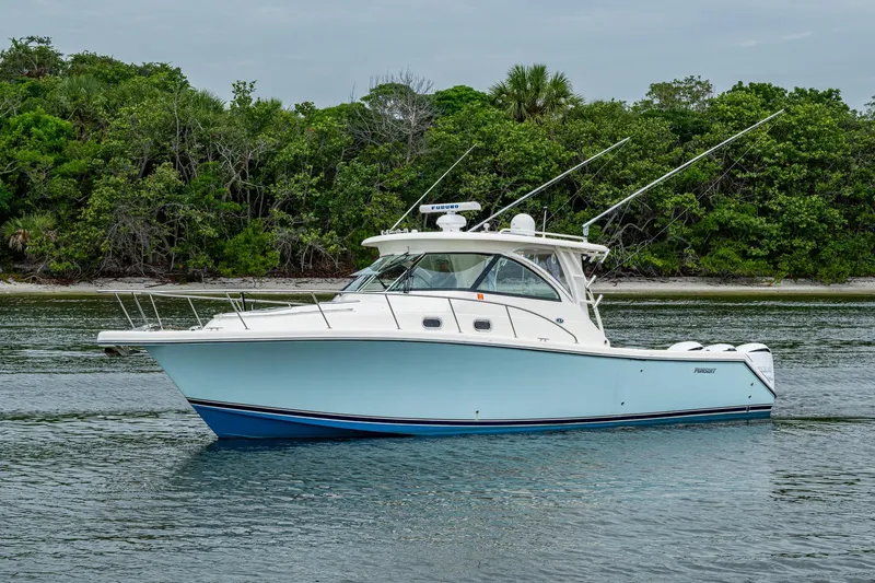 Bottoms Up II Yacht Photos Pics 2009 Pursuit OS 375 Offshore boat on calm water near lush green shoreline.
