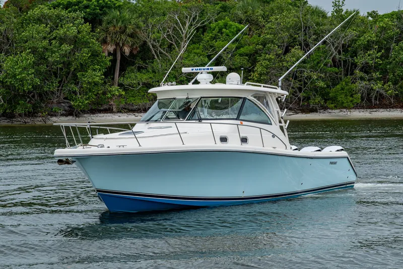 Bottoms Up II Yacht Photos Pics 2009 Pursuit OS 375 Offshore boat cruising near lush green shoreline.