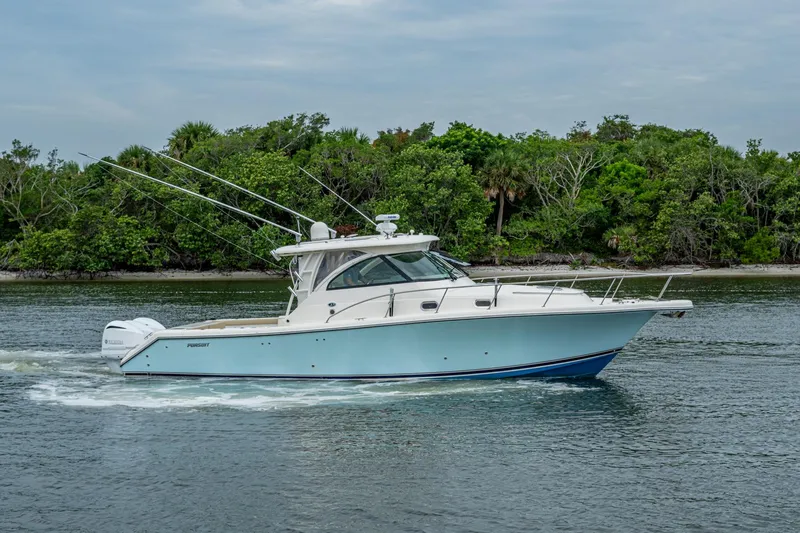 Bottoms Up II Yacht Photos Pics 2009 Pursuit OS 375 Offshore boat cruising near lush green shoreline.