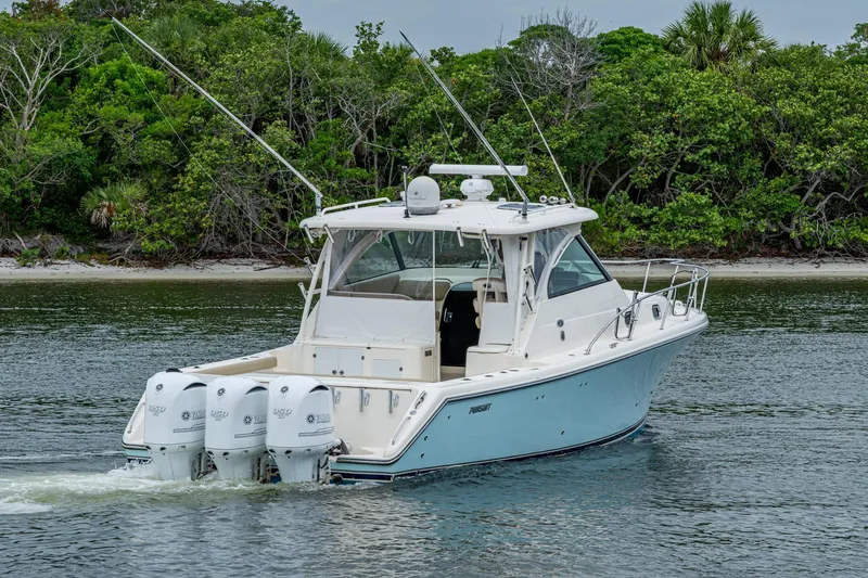 Bottoms Up II Yacht Photos Pics 2009 Pursuit OS 375 Offshore boat cruising near lush shoreline.