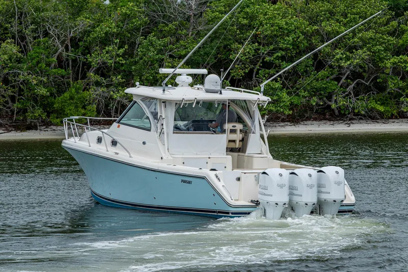 Bottoms Up II Yacht Photos Pics 2009 Pursuit OS 375 Offshore boat cruising near lush shoreline.