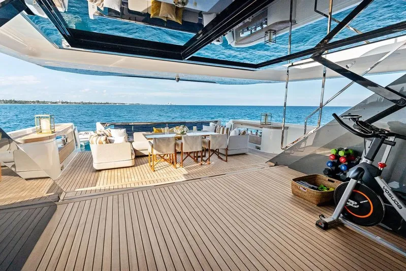 Randy Beth Yacht Photos Pics Luxurious 2018 Custom Line 120 yacht deck with seating, exercise bike, and ocean view.