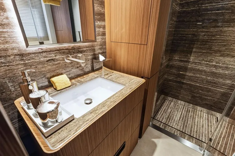 Randy Beth Yacht Photos Pics Luxurious bathroom with wooden cabinetry, modern sink, and elegant stone shower in Custom Line 120 yacht.