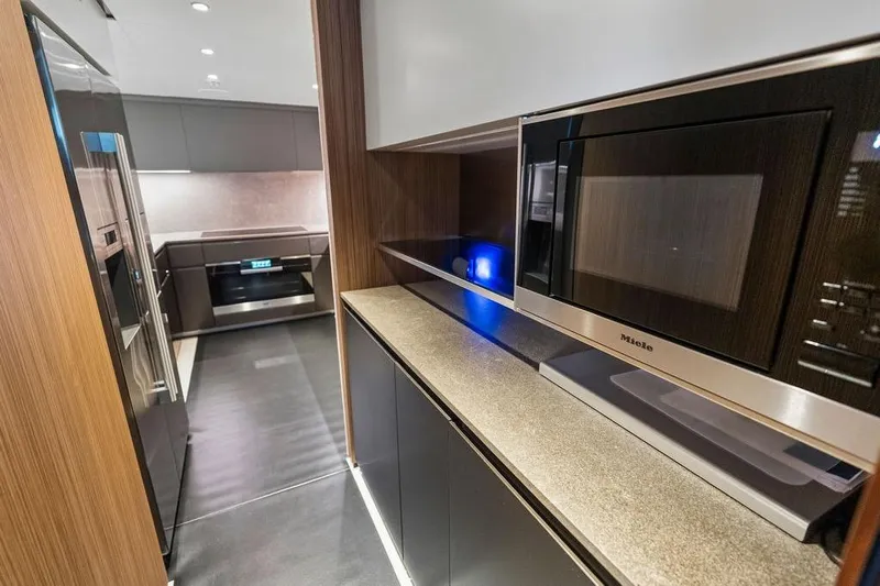 Randy Beth Yacht Photos Pics Modern kitchen interior with sleek appliances, featuring a Miele microwave, in a 2018 Custom Line 120 yacht.
