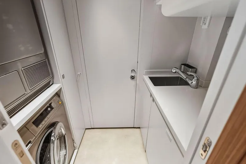 Randy Beth Yacht Photos Pics Compact laundry room with washer, dryer, and sink in a 2018 Custom Line 120 yacht.