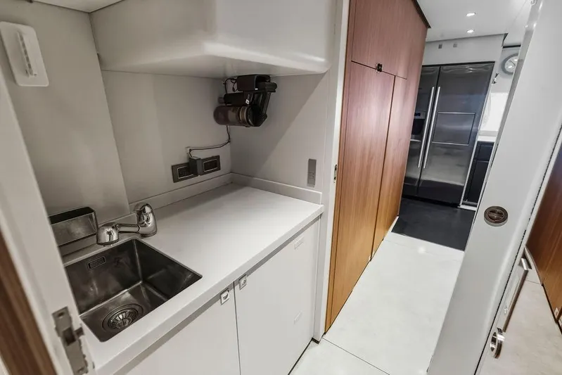 Randy Beth Yacht Photos Pics Modern yacht kitchen with sleek design, stainless steel sink, and wooden cabinetry, Custom Line 120, 2018.