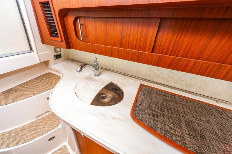  Yacht Photos Pics 2020 Grady-White 370 Express yacht interior with wooden cabinetry and modern sink.