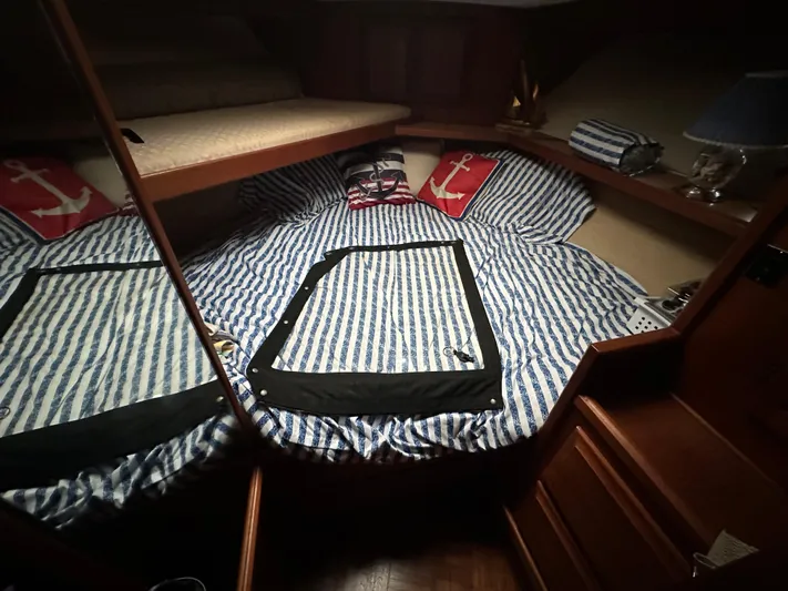 Last Dance Yacht Photos Pics Cozy cabin interior of 1987 Viking Boats 44 Motor Yacht with striped bedding and nautical decor.