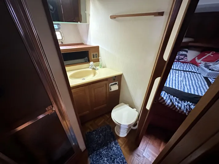 Last Dance Yacht Photos Pics 1987 Viking Boats 44 Motor Yacht bathroom with sink, toilet, and adjacent bedroom.