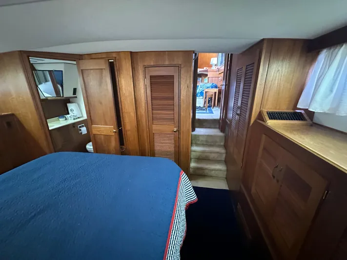 Last Dance Yacht Photos Pics 1987 Viking Boats 44 Motor Yacht interior cabin with wooden cabinetry and blue bedding.
