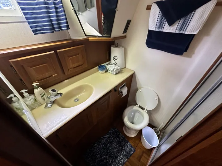 Last Dance Yacht Photos Pics 1987 Viking Boats 44 Motor Yacht bathroom with sink, toilet, and wooden cabinetry.