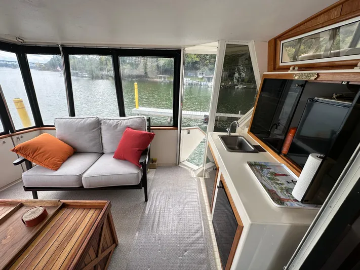 Last Dance Yacht Photos Pics Interior of 1987 Viking Boats 44 Motor Yacht with sofa, kitchenette, and lake view.