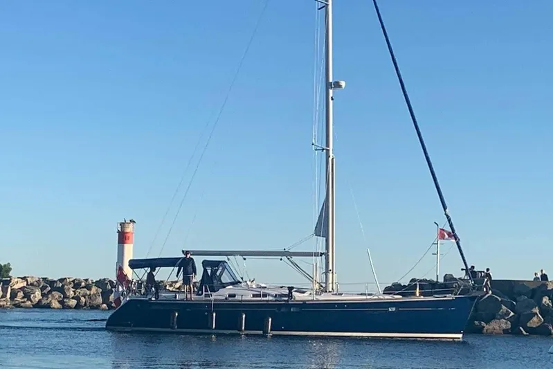 Rick B Yacht Photos Pics 2006 Beneteau 473 sailboat near a lighthouse on a sunny day.