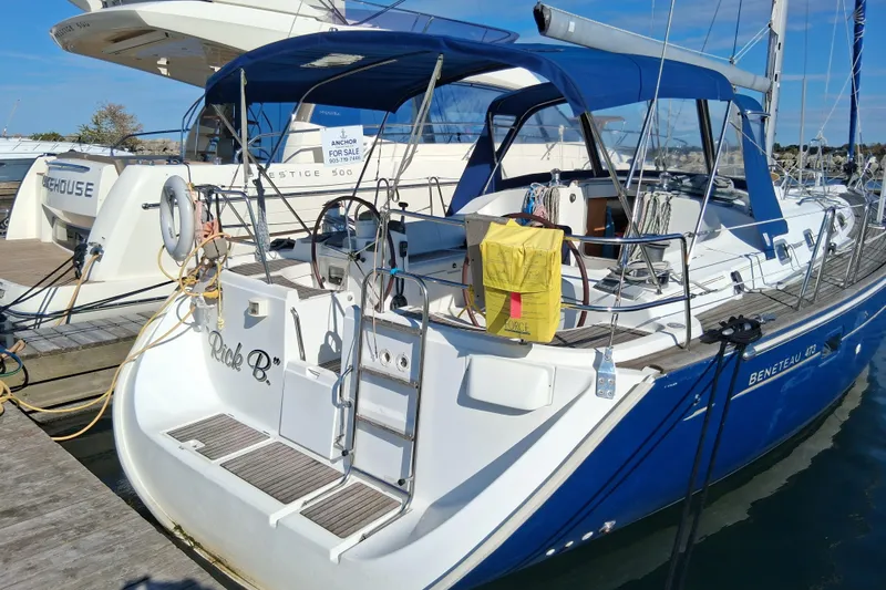 Rick B Yacht Photos Pics 2006 Beneteau 473 sailboat docked, featuring blue canopy and white hull.