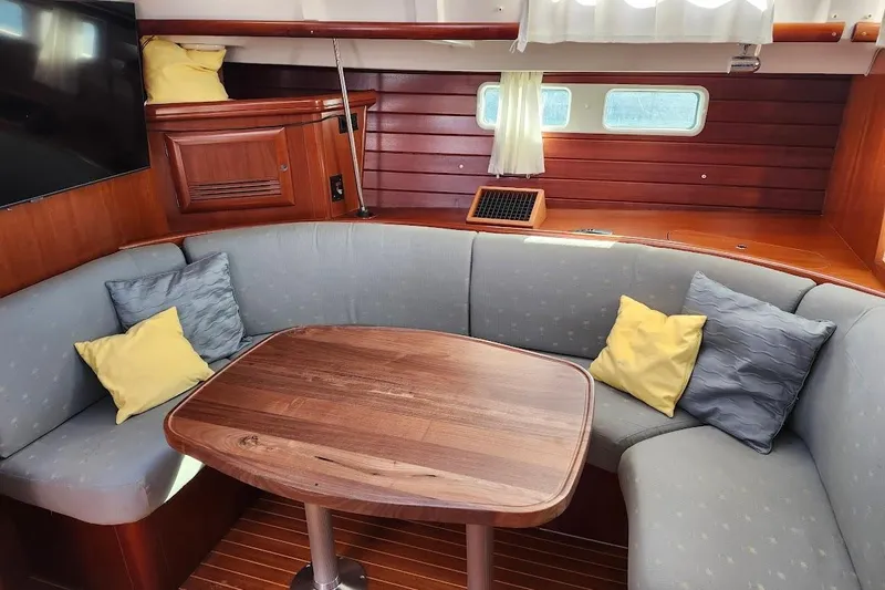 Rick B Yacht Photos Pics Cozy interior of 2006 Beneteau 473 yacht with cushioned seating and wooden table.