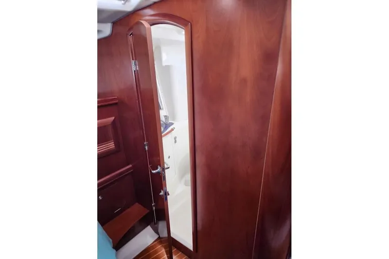 Rick B Yacht Photos Pics Interior view of 2006 Beneteau 473 yacht, featuring wooden door and cabinetry.