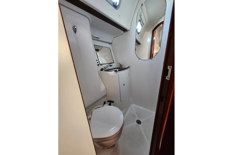 Rick B Yacht Photos Pics Bathroom interior of 2006 Beneteau 473 yacht, featuring toilet, sink, and mirror.