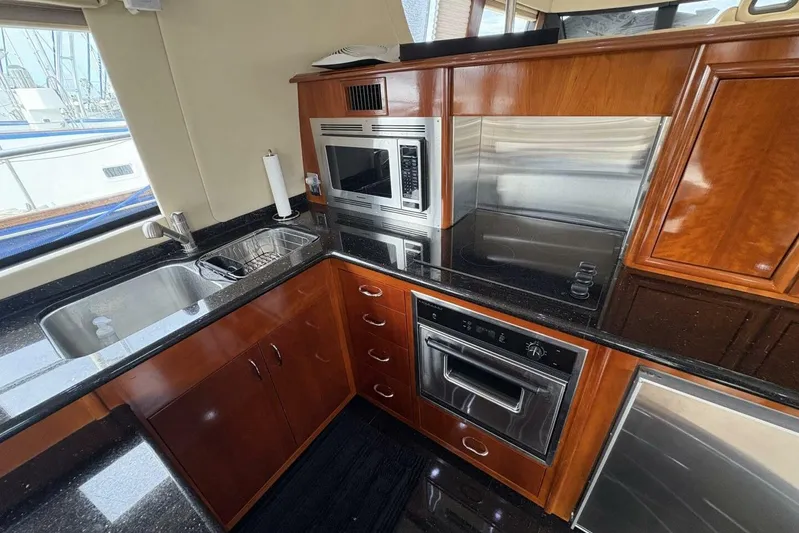 Carlet Vivian IV Yacht Photos Pics Luxurious kitchen in 2004 Carver 56 Voyager yacht with modern appliances and sleek wood cabinetry.