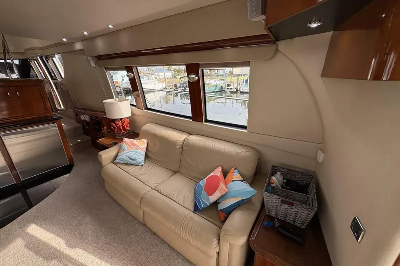 Carlet Vivian IV Yacht Photos Pics Luxurious interior of a 2004 Carver 56 Voyager yacht with beige sofa and colorful pillows.