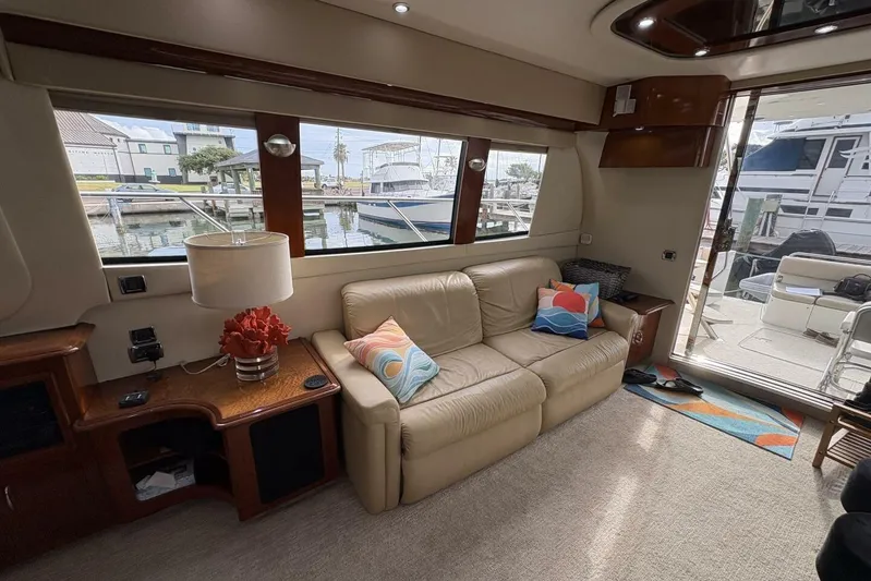 Carlet Vivian IV Yacht Photos Pics Luxurious interior of a 2004 Carver 56 Voyager yacht with beige leather sofa and colorful pillows.