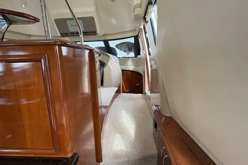 Carlet Vivian IV Yacht Photos Pics Interior of 2004 Carver 56 Voyager yacht with polished wood and carpeted flooring.