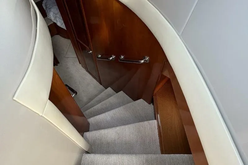 Carlet Vivian IV Yacht Photos Pics Interior staircase of 2004 Carver 56 Voyager yacht with wooden finish and carpeted steps.