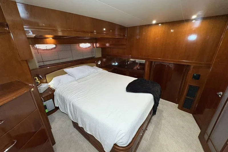 Carlet Vivian IV Yacht Photos Pics Luxurious bedroom interior of 2004 Carver 56 Voyager yacht with wood paneling.