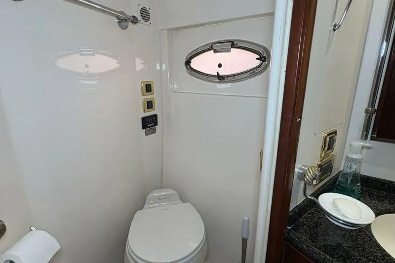 Carlet Vivian IV Yacht Photos Pics 2004 Carver 56 Voyager yacht bathroom with porthole, toilet, and sink area.