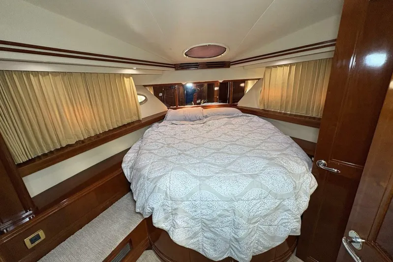 Carlet Vivian IV Yacht Photos Pics Luxurious bedroom interior of 2004 Carver 56 Voyager yacht with elegant bedding and wood accents.