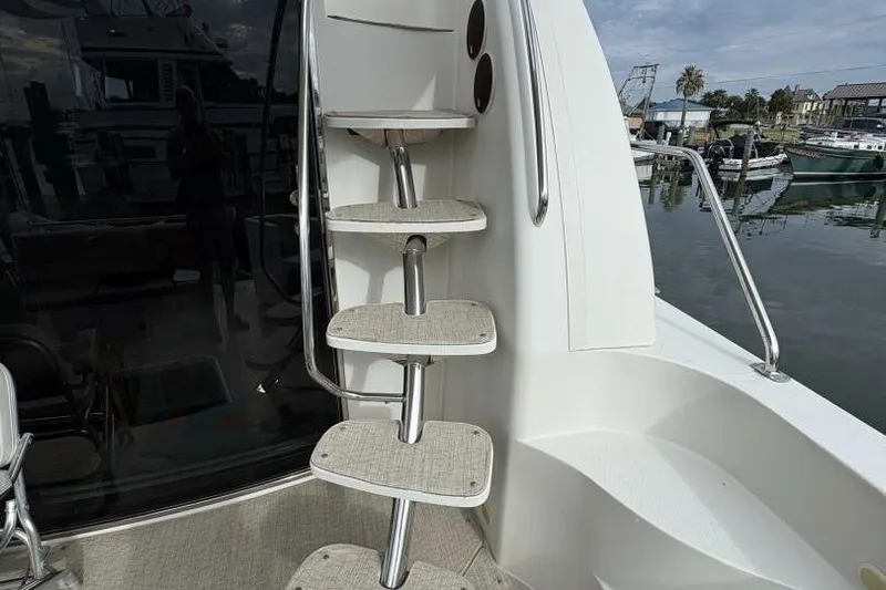 Carlet Vivian IV Yacht Photos Pics Staircase on 2004 Carver 56 Voyager yacht, docked at marina with boats in background.