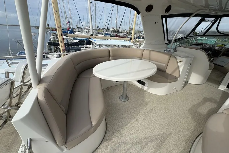 Carlet Vivian IV Yacht Photos Pics 2004 Carver 56 Voyager yacht interior with curved seating and round table in a marina setting.