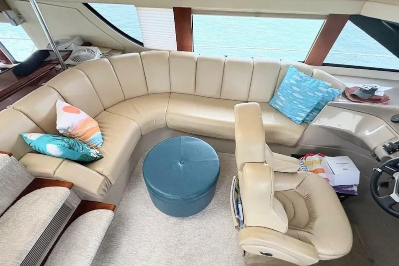 Carlet Vivian IV Yacht Photos Pics Luxurious interior of 2004 Carver 56 Voyager yacht with beige leather seating and colorful pillows.