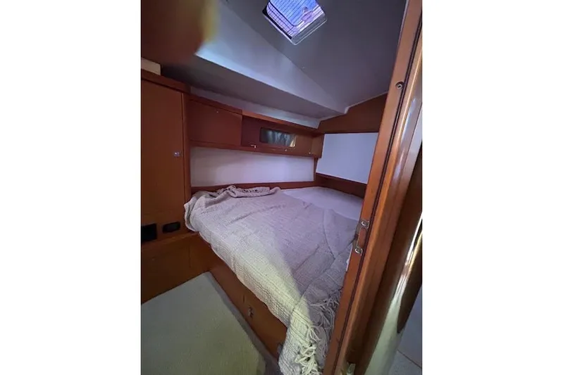 Yacht Photos Pics Cozy cabin interior of 2013 Beneteau Sense 46 yacht with bed and wooden furnishings.