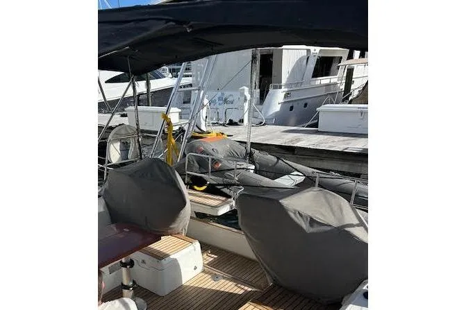  Yacht Photos Pics 2013 Beneteau Sense 46 yacht docked, featuring covered seating and a shaded deck area.