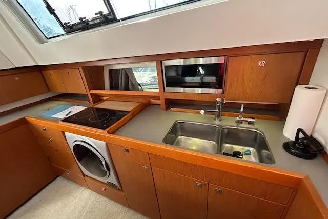  Yacht Photos Pics Modern kitchen in 2013 Beneteau Sense 46 yacht with sink, stove, and microwave.