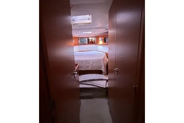  Yacht Photos Pics 2013 Beneteau Sense 46 yacht interior, featuring a cozy bedroom with warm lighting.