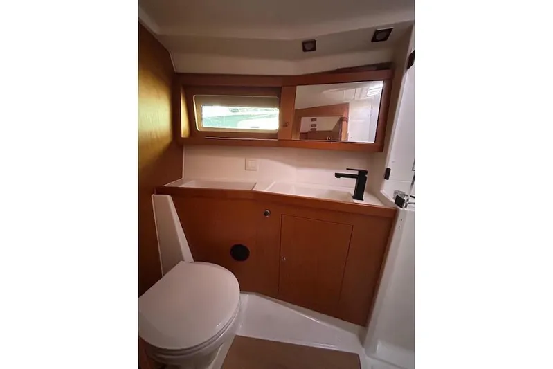  Yacht Photos Pics Bathroom interior of 2013 Beneteau Sense 46 yacht with wooden cabinetry and modern fixtures.
