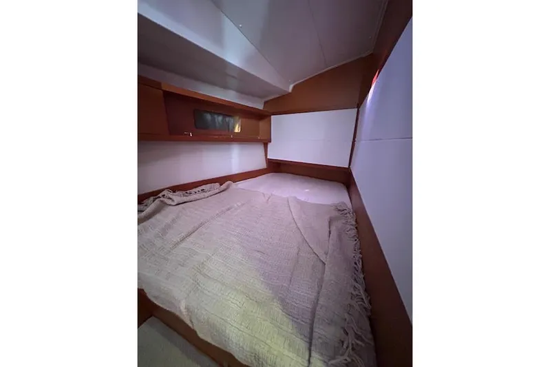  Yacht Photos Pics Cozy cabin interior of 2013 Beneteau Sense 46 yacht with bed and wooden accents.