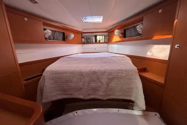  Yacht Photos Pics Interior cabin of 2013 Beneteau Sense 46 yacht, featuring a cozy bed and wooden finish.