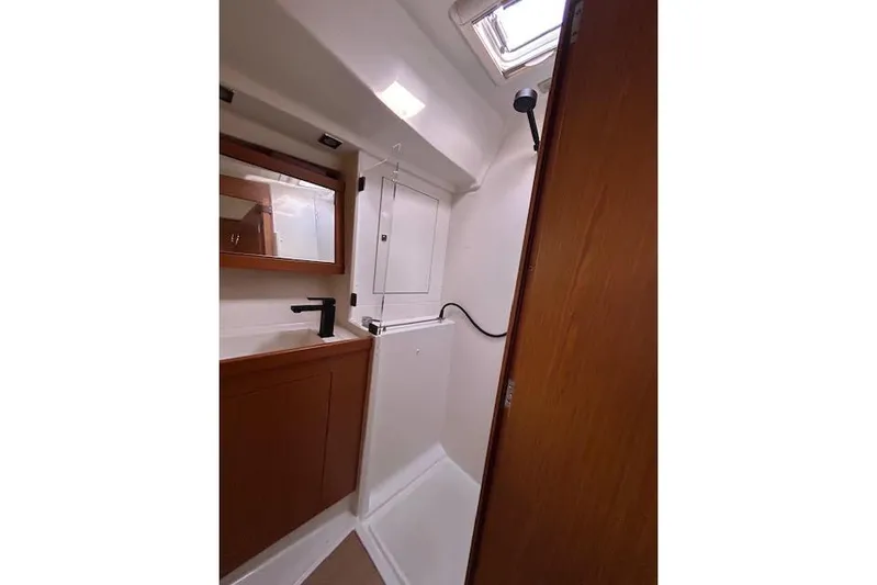  Yacht Photos Pics 2013 Beneteau Sense 46 yacht bathroom with shower, mirror, and wooden cabinetry.