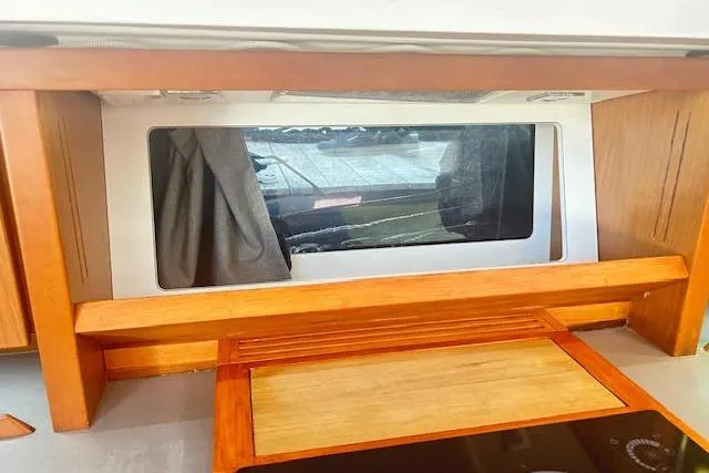  Yacht Photos Pics Interior view of 2013 Beneteau Sense 46 yacht, featuring a wooden cabinet and window.