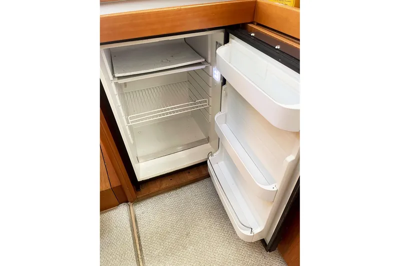  Yacht Photos Pics Open refrigerator inside 2013 Beneteau Sense 46 yacht, featuring shelves and door compartments.