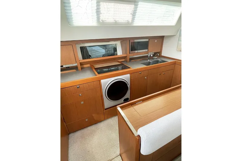  Yacht Photos Pics Interior of 2013 Beneteau Sense 46 yacht kitchen with wood cabinetry and modern appliances.