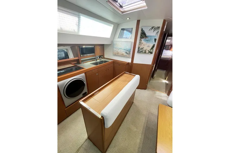  Yacht Photos Pics Interior of 2013 Beneteau Sense 46 yacht, featuring modern kitchen and cozy seating area.