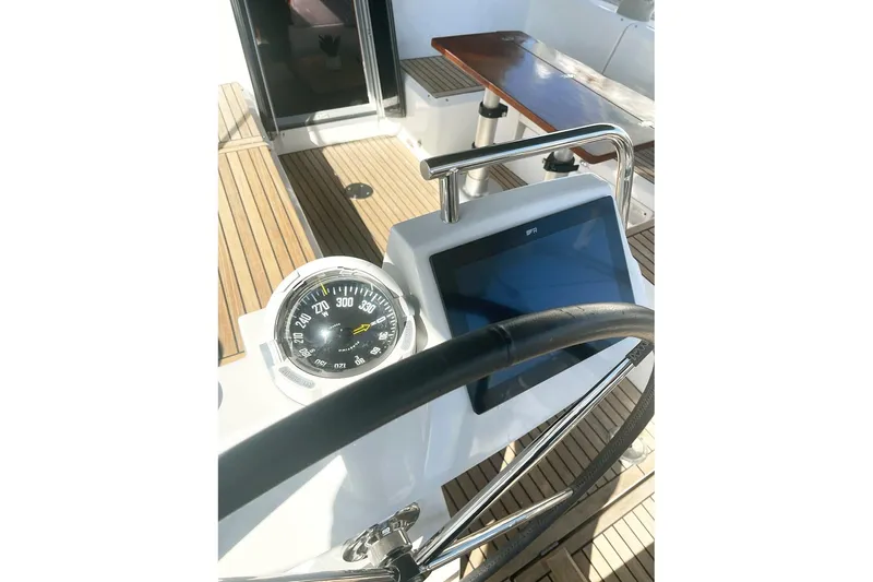  Yacht Photos Pics Cockpit of 2013 Beneteau Sense 46 sailboat with compass and navigation display.