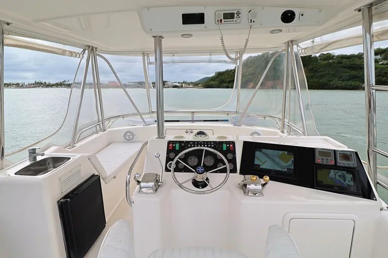  Yacht Photos Pics 2000 Riviera Flybridge Convertible yacht helm with steering wheel and navigation screens.