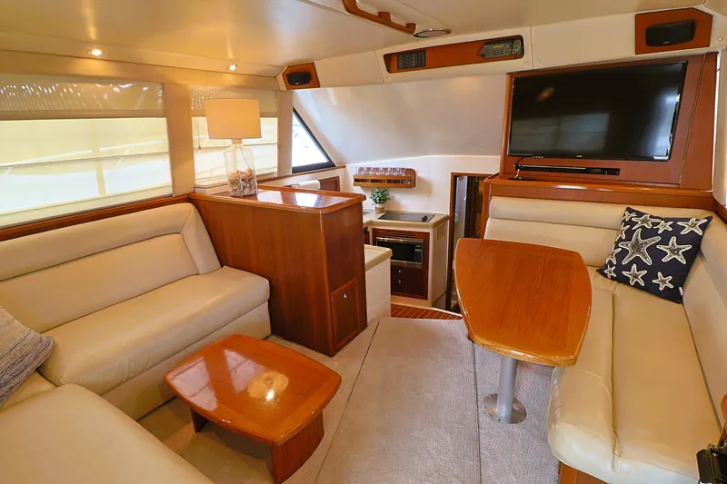  Yacht Photos Pics Luxurious interior of 2000 Riviera Flybridge Convertible yacht with plush seating and modern amenities.